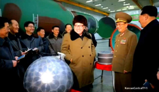North Korean leader, Kim Jong-Un, beams proudly next to a miniaturized nuke from last year while sporting the always trendy, communist Ushanka hat.
