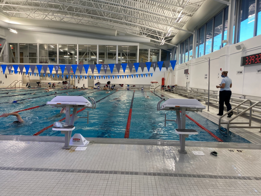 Coach Moretti times a swimmer during practice on November 16, 2021 