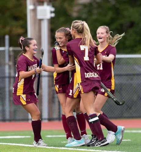 Girls Field Hockey celebrate after scoring a goal.